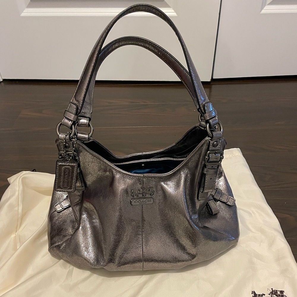 Coach gunmetal shoulder bag with three pockets and blue satin interior.